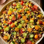 Cowboy caviar couscous salad with black beans, corn, tomatoes, cucumber, and jalapeños