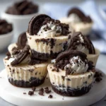 No-Bake Oreo Cheesecake Cups topped with whipped cream, crushed Oreos, and chocolate cookies